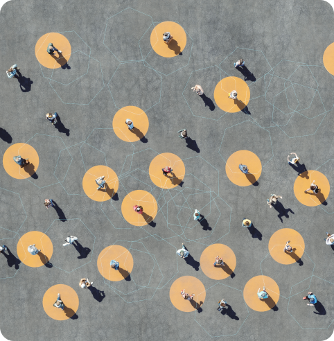 overhead view of people standing on gray pavement with yellow circles